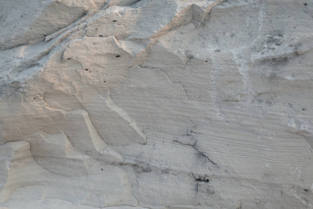 istock Wallpaper with limestone rock face showing weathered strata Geology background 998933656