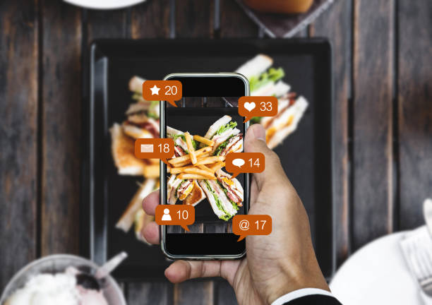 scattare foto di cibo tramite smartphone mobile e condividerlo sui social media, social network con icone di notifica - food photography foto e immagini stock