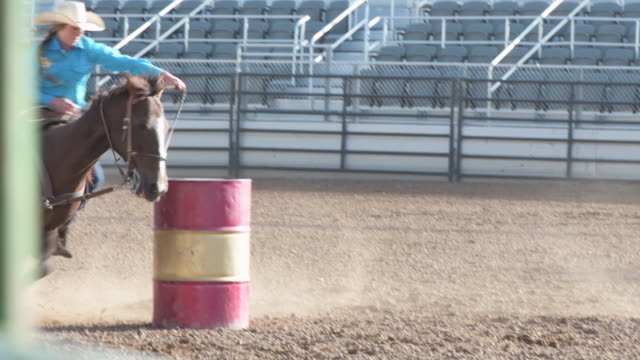 Young university rodeo cowgirl barrel racing