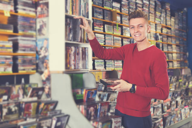 istock Man choosing movies on DVD 998950820