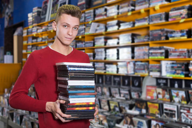 istock guy holding pile of boxes with DVDs 998950904