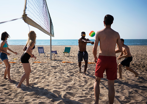 Young people playing volleyball at the beach