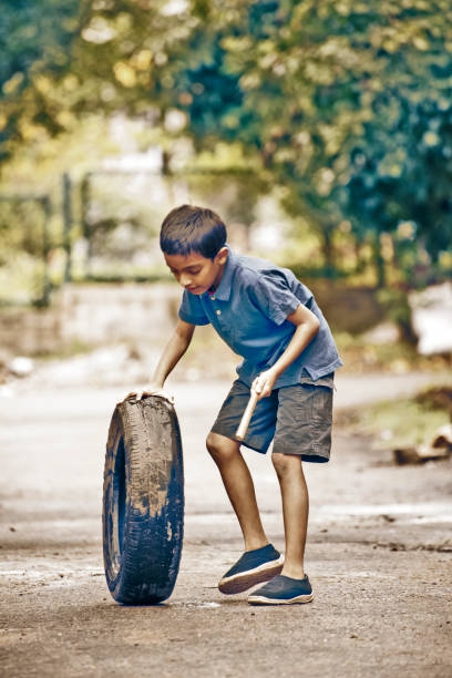 barefoot boy riding bike on outdoor ground