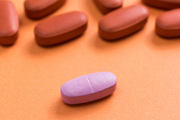 istock Close-Up Of Pills On Orange Table 998961202