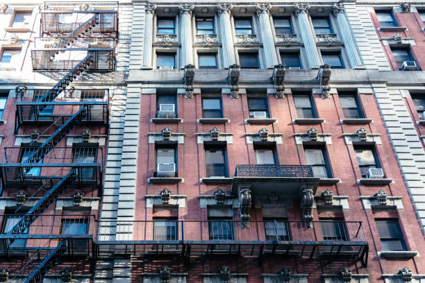 istock Low angle view of old apartment building with fire escape in New 998967710