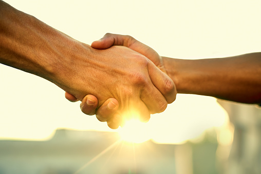 Cropped shot of two people shaking hands outdoors