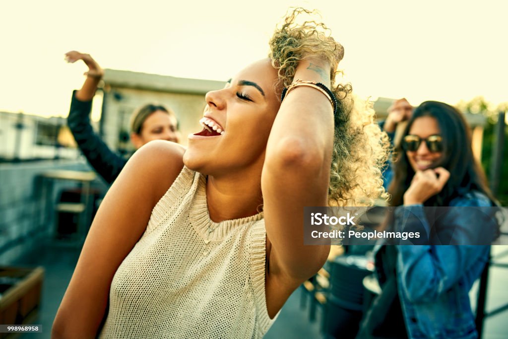 There's always that one song that gets everyone dancing Shot of a group of young women dancing and having fun together outdoors Dancing Stock Photo