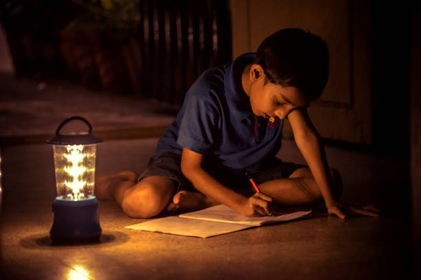 istock 7 years Indian Boy studying under lamp 998976076