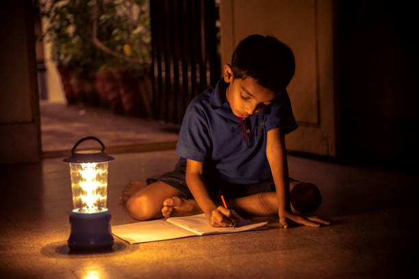 7 years Indian Boy studying under lamp