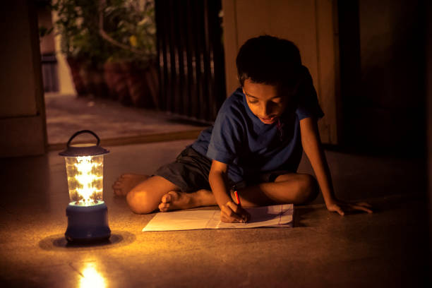 7 years Indian Boy studying under lamp power cut, solar energy,education, power, writing, boy, India, night blackout photos stock pictures, royalty-free photos & images