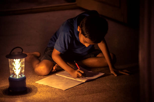 istock 7 years Indian Boy studying under lamp 998976102