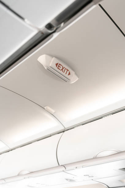 istock emergency exit sign on airplane. Empty airplane seats in the cabin. Modern Transportation concept. Aircraft long-distance international flight 998976864