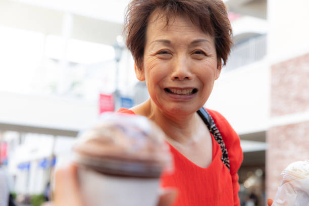 haute femme japonaise apportant boisson froide - disposable cup coffee shopping friendship photos et images de collection