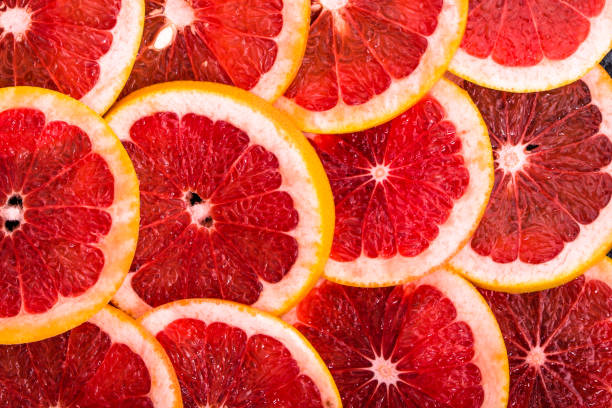 istock Sliced grapefruits, background, natural texture of citrus, top view, close-up 998983278