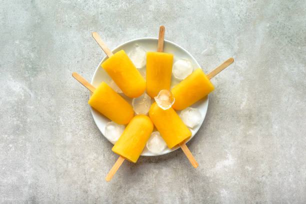 istock Orange popsicles. Homemade ice pops, overhead, flat lay 998983918