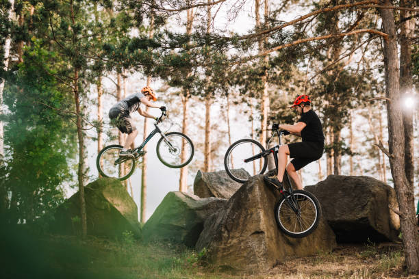 istock trial bikers performing stunts on rocks outdoors 998984046