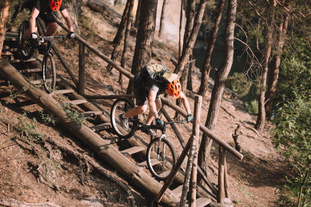 istock young trial bikers riding down stairs in forest 998984132