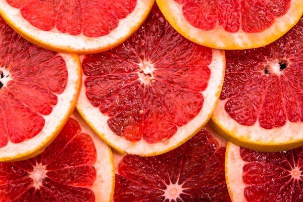 istock Sliced grapefruits, background, natural texture of citrus, top view, close-up 998987230