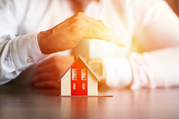 istock Business man hand hold the house model saving small house 998988610