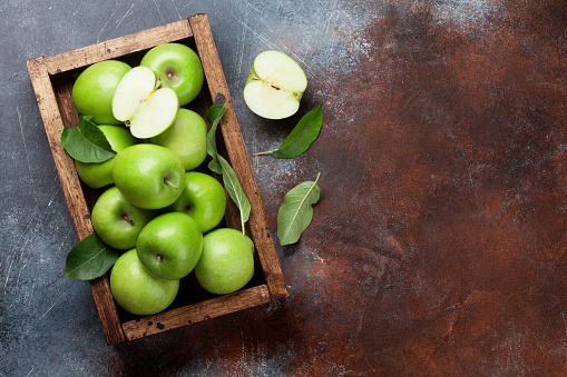 Ripe green apples in wooden box. Top view with space for your text
