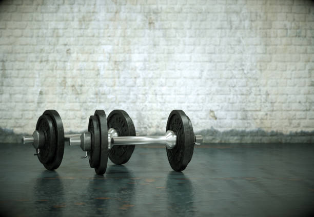 istock Dumbbell with black plates on a gym floor 998993256