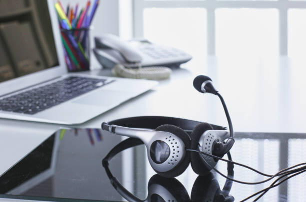 istock Communication support, call center and customer service help desk. VOIP headset on laptop computer keyboard 998996866