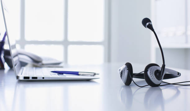 istock Communication support, call center and customer service help desk. VOIP headset on laptop computer keyboard 998997104