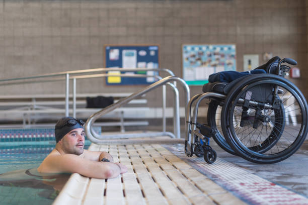 athlète adaptative s’apprête à nager dans une piscine - sports en fauteuil roulant photos et images de collection