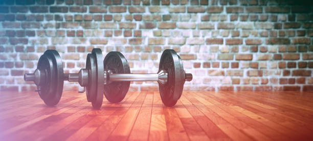 istock Dumbbell with black plates on a gym floor 998997790