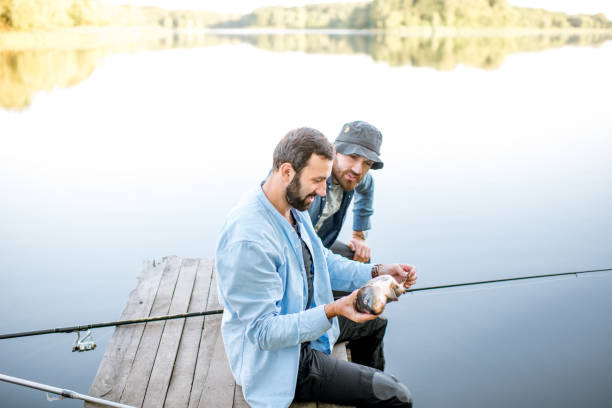 istock Fishermen with fish on the lake 999000848