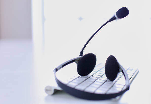 istock Communication support, call center and customer service help desk. VOIP headset on laptop computer keyboard 999001338