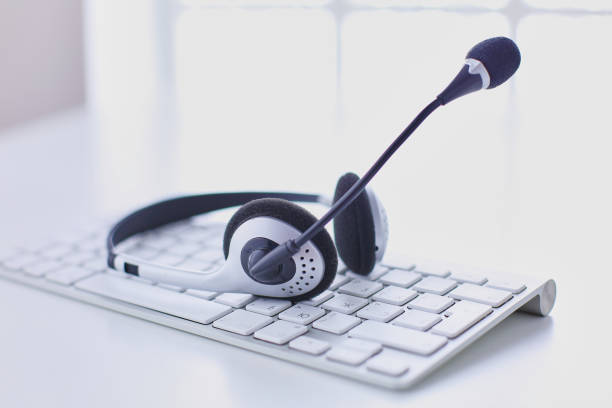 istock Communication support, call center and customer service help desk. VOIP headset on laptop computer keyboard 999002004