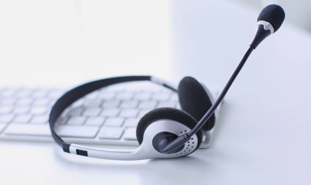 istock Communication support, call center and customer service help desk. VOIP headset on laptop computer keyboard 999004152