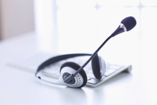 istock Communication support, call center and customer service help desk. VOIP headset on laptop computer keyboard 999004188