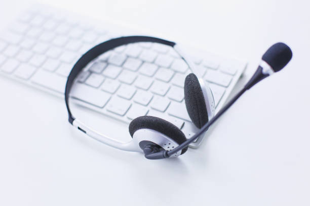 istock Communication support, call center and customer service help desk. VOIP headset on laptop computer keyboard 999004232