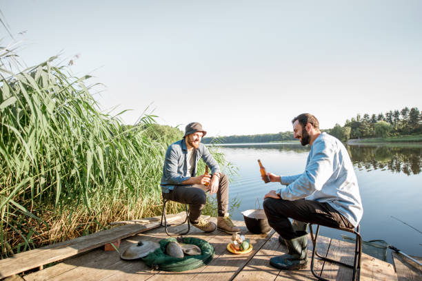 istock Men relaxing with beer while fishing on the lake 999004880
