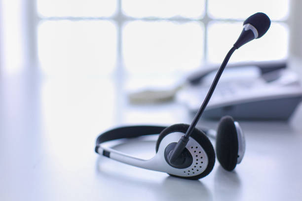 istock Communication support, call center and customer service help desk. VOIP headset on laptop computer keyboard 999005160