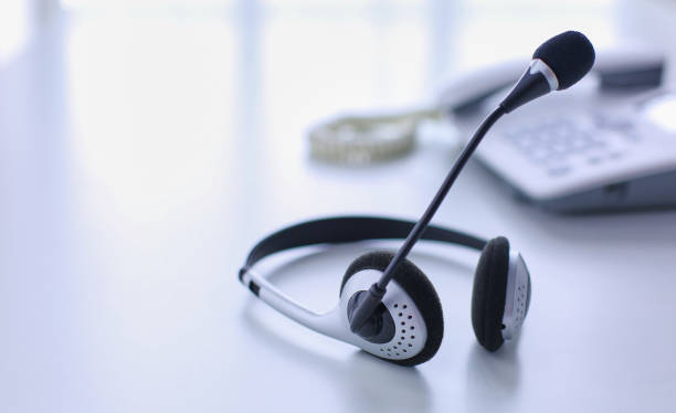istock Communication support, call center and customer service help desk. VOIP headset on laptop computer keyboard 999005220