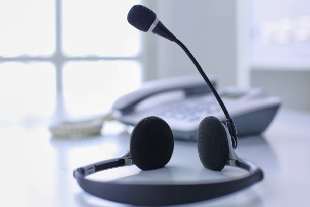 istock Communication support, call center and customer service help desk. VOIP headset on laptop computer keyboard 999005354