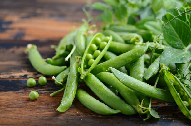 frais biologiques pois sur fond en bois rustique. - petit pois photos et images de collection