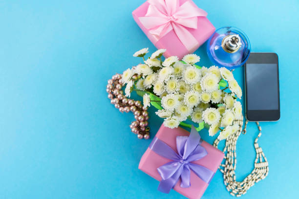 dekoracyjne pudełka kompozycji z prezentami kwiaty biżuteria damska zakupy wakacje niebieskie tło. - pink perfume bracelet necklace zdjęcia i obrazy z banku zdjęć