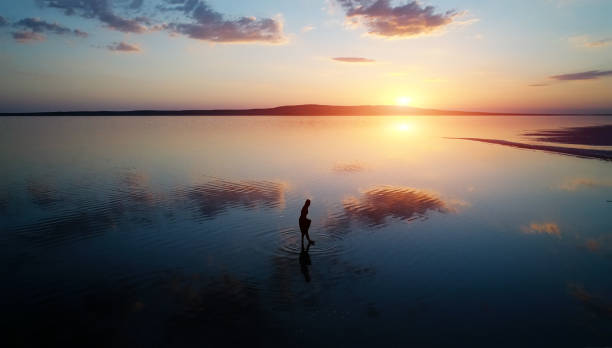 istock Ballerina dancing on the lake at sunset. 999021984