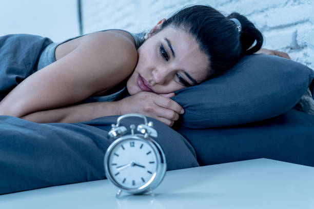 young beautiful hispanic woman at home bedroom lying in bed late at night trying to sleep suffering insomnia sleeping disorder or scared on nightmares looking sad worried in mental health concept stock photo