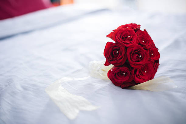 istock Bouquet of Red Romantic Roses on White Bed 999027066