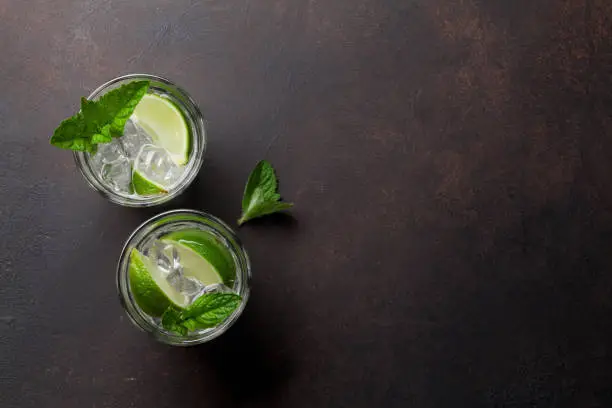 Two Mojito cocktail glasses on stone table. Top view with copy space
