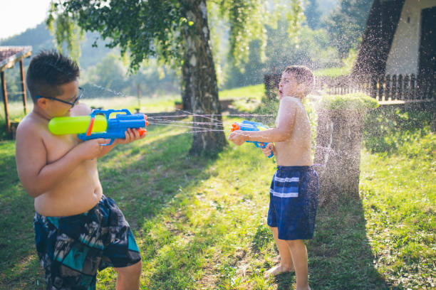 istock Little boys playing with water guns in summer 999038478