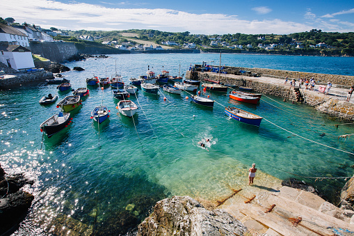 Coverack, Cornwall, UK - June 26, 2018. A high angle view of the picturesque harbour and fishing village of Coverack in Cornwall, UK which is a popular tourist destination in the South West of England.