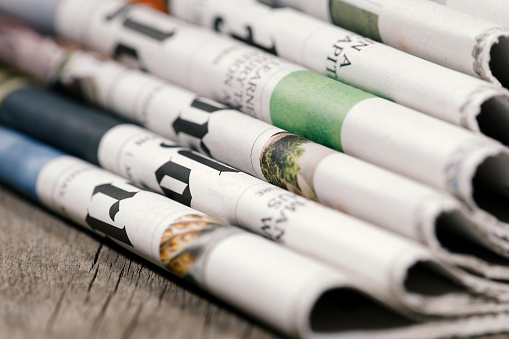 Stack of newspapers on wooden table