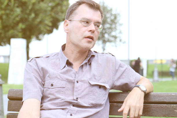 istock Man sitting in public park 999058696