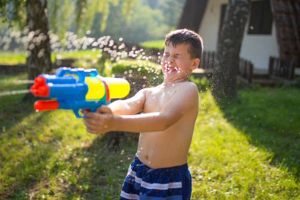istock Little boy splashing with water gun 999059472